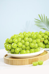Fresh Green Grapes on White Plate with Palm Leaf - Healthy Fruit Display