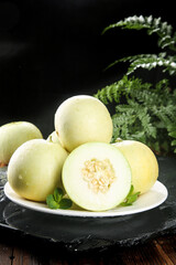 Fresh Honeydew Melons on Plate with Fern Leaves - Healthy Summer Fruit Display