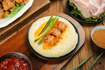 Korean BBQ grilled meat with rice porridge and traditional side dishes on wooden table