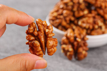 Fresh Amber Walnuts from Yunnan Xinjiang - Hand Holding Premium Quality Nut Kernel with Bowl Background