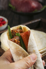 Traditional Chinese Barbecue Meat Wrap with Red Sauce - Flavorful Street Food in Hand