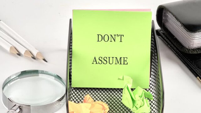 Text animation DO NOT ASSUME on a green sticker on the table. Evidence or information concept