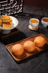 Traditional Yunnan Xuanwei Ham Mooncakes and Chinese Pastries with Tea Service on Wooden Tray