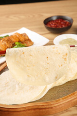 Fresh Flour Tortillas with Red Salsa and Mexican Appetizers on Wooden Serving Board
