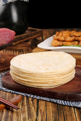 Fresh Flour Tortillas Stack on Wooden Board with BBQ Ingredients for Mexican Cooking
