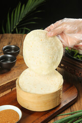 Traditional Asian Steamed Wheat Buns in Bamboo Steamer Basket with Chopsticks