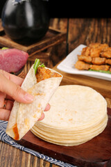 Spicy Jerk Chicken Wrap with Tortillas and Fried Plantains on Rustic Wooden Table