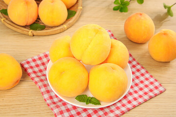 Fresh Yellow Peaches on Wooden Table with Red Checkered Cloth - Healthy Summer Fruit Display