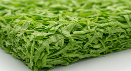 Close-up of Shredded Bright Green Leafy Vegetables on White Background
