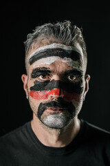 Man with Bold Tribal Face Paint Staring Intently