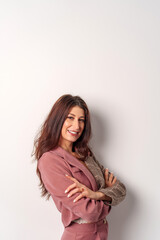 Obraz premium Portrait of a smiling businesswoman wearing pink suit with crossed arms, exuding confidence and professionalism against a white background