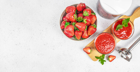 Fresh strawberries and strawberry smoothie in glasses with mint on white background, top view, copy space. Artificial intelligence technology in modern food industry