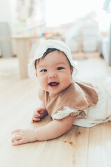 ボンネットをかぶるうつ伏せの赤ちゃん