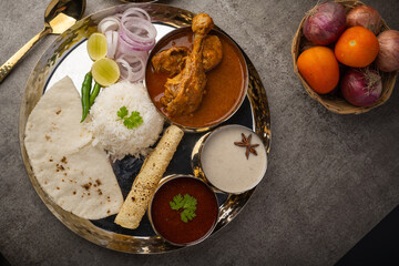 Kolhapuri chicken Thali is a popular Indian asian food platter consists of poultry meat, chikan sukka bhakri, rice, salad tambda padhra rassa 