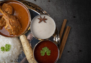 Kolhapuri chicken Thali is a popular Indian asian food platter consists of poultry meat, chikan sukka bhakri, rice, salad tambda padhra rassa 