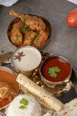 Kolhapuri chicken Thali is a popular Indian asian food platter consists of poultry meat, chikan sukka bhakri, rice, salad tambda padhra rassa 
