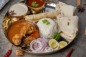 Kolhapuri chicken Thali is a popular Indian asian food platter consists of poultry meat, chikan sukka bhakri, rice, salad tambda padhra rassa 
