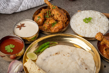 Kolhapuri chicken Thali is a popular Indian asian food platter consists of poultry meat, chikan sukka bhakri, rice, salad tambda padhra rassa 