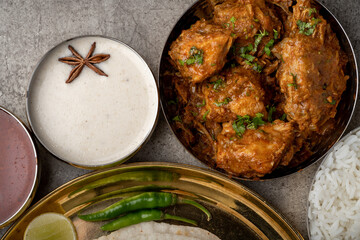 Kolhapuri chicken Thali is a popular Indian asian food platter consists of poultry meat, chikan sukka bhakri, rice, salad tambda padhra rassa 