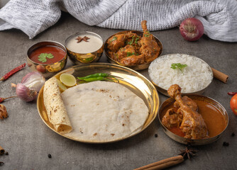 Kolhapuri chicken Thali is a popular Indian asian food platter consists of poultry meat, chikan sukka bhakri, rice, salad tambda padhra rassa 