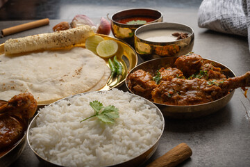 Kolhapuri chicken Thali is a popular Indian asian food platter consists of poultry meat, chikan sukka bhakri, rice, salad tambda padhra rassa 