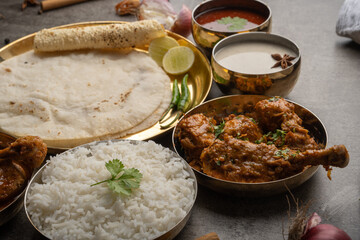 Kolhapuri chicken Thali is a popular Indian asian food platter consists of poultry meat, chikan sukka bhakri, rice, salad tambda padhra rassa 