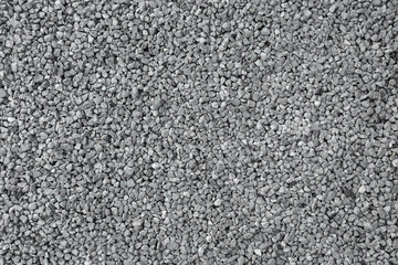 Light gray granite gravel road background. Closeup. Empty place for text. Top down view.