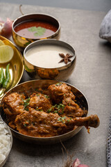 Kolhapuri chicken Thali is a popular Indian asian food platter consists of poultry meat, chikan sukka bhakri, rice, salad tambda padhra rassa 