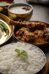 Kolhapuri chicken Thali is a popular Indian asian food platter consists of poultry meat, chikan sukka bhakri, rice, salad tambda padhra rassa 