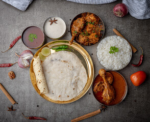 Kolhapuri chicken Thali is a popular Indian asian food platter consists of poultry meat, chikan sukka bhakri, rice, salad tambda padhra rassa 