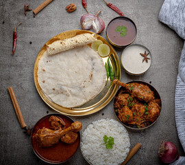 Kolhapuri chicken Thali is a popular Indian asian food platter consists of poultry meat, chikan sukka bhakri, rice, salad tambda padhra rassa 