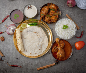 Kolhapuri chicken Thali is a popular Indian asian food platter consists of poultry meat, chikan sukka bhakri, rice, salad tambda padhra rassa 