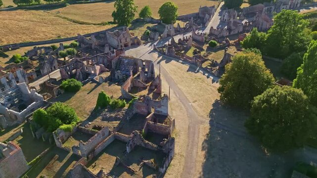 Aerial top view of ruined village Oradour-sur-Glane with fields, path, and solemn mood.