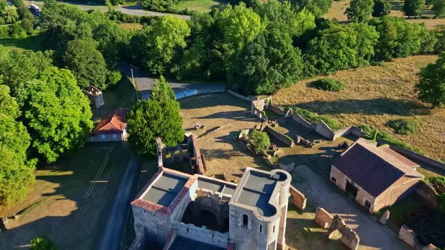 Aerial view of ruined church and houses in Oradour-sur-Glane at golden hour.