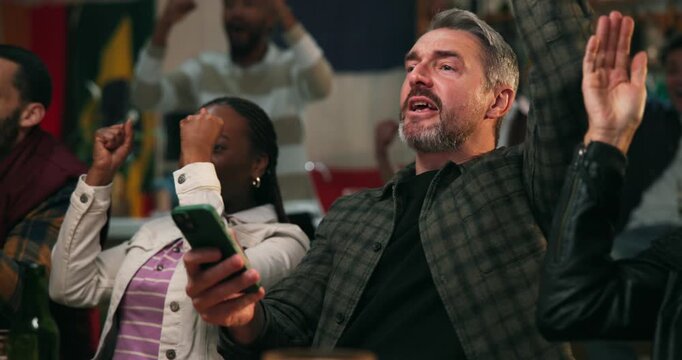 Winner, phone and cheering with man at pub for streaming game, sports score or goal. Team support, fans celebration and competition with people watching tv in bar for live broadcast and match results