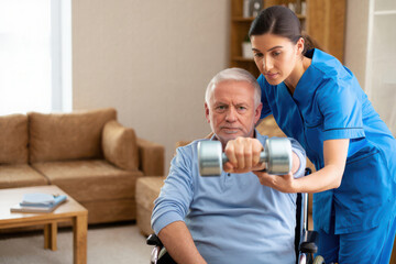 Nurse assisting elderly man in wheelchair with weightlifting exercise