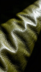 Leather's Embrace:  Intimate close-up of soft, textured leather surface, revealing rich details and subtle folds, bathed in dramatic lighting, invoking tactile sensations and luxury.