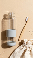 Eco-Friendly Routine: A close-up shot captures an assortment of eco-friendly accessories arranged thoughtfully. a glass bottle, a toothbrush, and a cotton bag showcase a dedication to the environment.