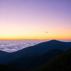 Naklejka premium Mountain Sunset with Bird Flying over Clouds