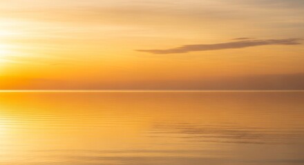 Obraz premium Peaceful Golden Hour Seascape: Calm Water Reflecting a Warm Sky with Wispy Clouds
