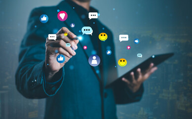 Business professional interacting with digital tablet and floating social media icons including likes, chat, and emojis. Concept for online marketing, networking, and digital communication.