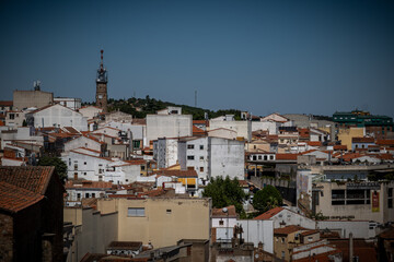 Vista panorámica del casco histórico de la ciudad española de Cáceres con vistas a los tejados de tejas marrones de edificios antiguos alrededor de la plaza principal en el soleado día de verano