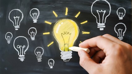 Hand drawing a glowing light bulb surrounded by other bulbs on a chalkboard