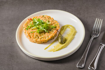 Baked vegetable patty with pea puree and microgreens garnish