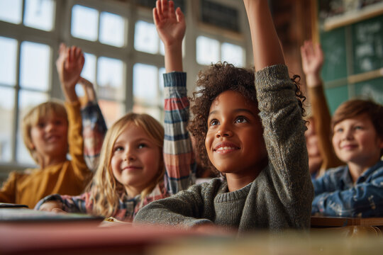 Curious elementary students eagerly raise their hands in a bright classroom, smiling and engaged during a lesson — diverse kids learning and participating - Powered by Adobe
