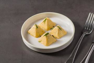 Four pyramid shaped herb cheese bites served with chives