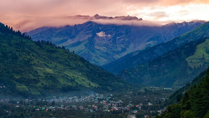Scenic panorama of Manali and Kullu Valley with high Himalayan peaks, Himachal Pradesh, India. The dramatic 5000m peaks, lush green hills, and glowing sunset clouds create a peaceful © NICK