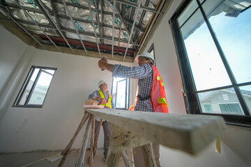 Construction workers collaborating on interior framing in a residential building project