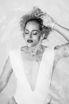 Fashion model wearing white swimsuit posing underwater