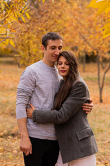 Fototapeta premium Loving couple hugging each other in an autumn park. autumn mood, autumn concept, fall. Husband and wife, groom and bride, dad and mom